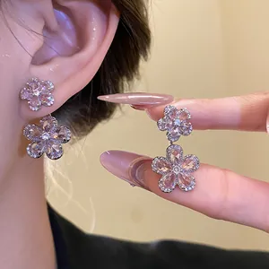 Elegant silver needle flower drop earrings with pink zircons worn by Asian model