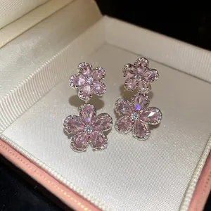 Close-up of elegant pink zircon flower drop earrings with sparkling details in a gift box
