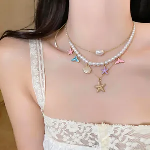 Detailed view of layered beach style necklace featuring pearls, starfish, and shell charms