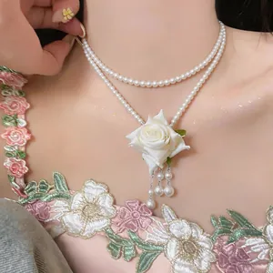 Gros plan d'un élégant collier de perles double épaisseur avec rose en tissu blanc