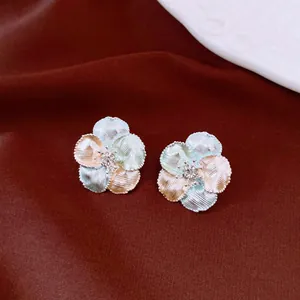 Detailed macro view of elegant multi-color textured flower stud earrings with zircon center