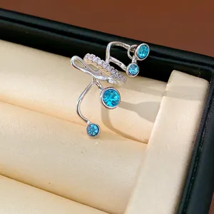 Close-up of a silver-toned multi-layer ear cuff with sparkling blue zircon stones.
