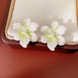 Close-up of elegant flower stud earrings with pearly white petals and zircon centers