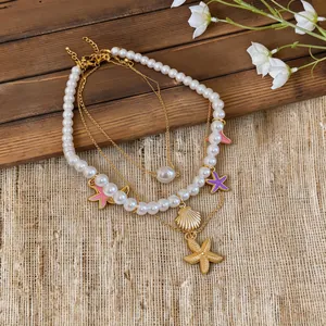 Detail of layered necklace with shell and starfish charms on a rustic background.