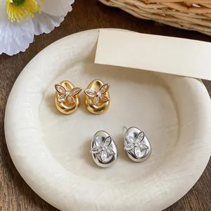 Elegant butterfly cubic zirconia stud earrings in gold and silver finishes on a tray