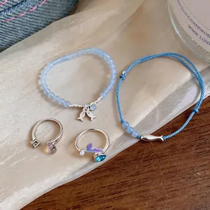 Summer jewelry set with blue beaded fish bracelet and dainty woven cord matching rings