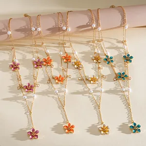 Detailed view of colorful enamel flower necklaces with pearls and crystals in four vibrant colors.