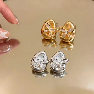 Detailed macro shot of elegant gold and silver butterfly zircon waterdrop stud earrings