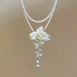 Détail en gros plan d'un élégant collier de perles à deux rangs avec rose en tissu