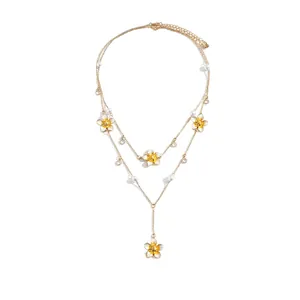 Elegant double layer gold necklace featuring white pearls and enameled yellow flower pendants