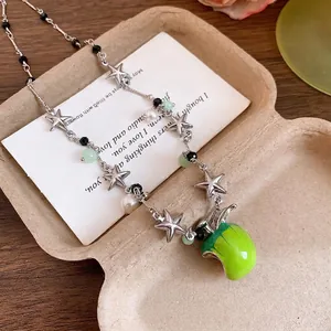 Élégant collier de perles et d'étoiles argentées avec un pendentif pomme en émail vert