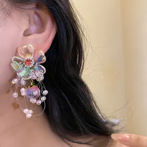 Close-up of elegant iridescent floral tassel earring with silver needle and beads
