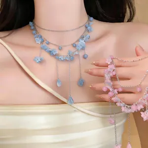 Elegante mehrlagige Halskette mit zarten blauen und rosa Blütenblättern und feinen Quasten
