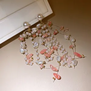 Detail of light luxury tassel earrings with pearls and pink stones on a display box