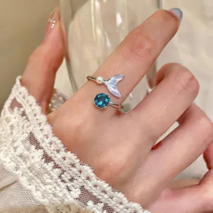 Detailed view of elegant mermaid tail open ring with blue gemstone and pearl accent