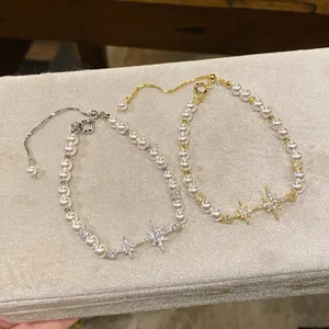Macro detail view of elegant pearl bracelets featuring sparkling zircon star charms