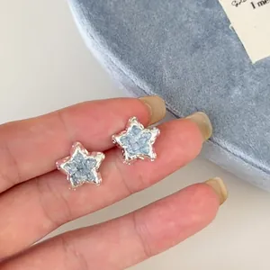 Detailed macro shot of star-shaped stud earrings with light blue crushed ice texture