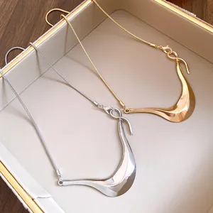 Detail von unregelmäßigen geometrischen Metallanhänger-Halsketten in Gold und Silber