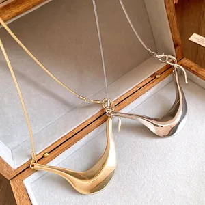 Nahaufnahme minimalistischer unregelmäßiger geometrischer Halsketten in Gold und Silber