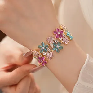 Elegante bracciale dorato a doppio strato con fiori di zirconi colorati sul polso