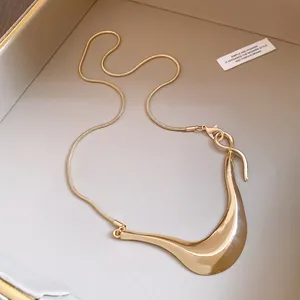 Nahaufnahme der goldenen unregelmäßigen geometrischen Halskette mit Schlangenkette