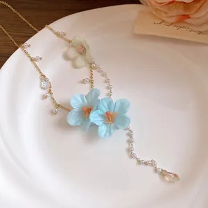 Close-up of fabric flower necklace with pearls and a sparkling crystal drop pendant