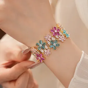 Dettaglio di un bracciale a doppio strato con fiori di zirconi colorati