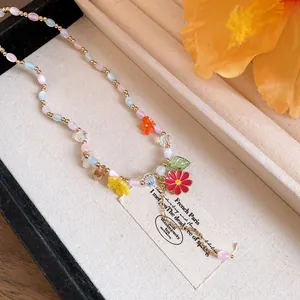 Detailopname van kleurrijke kralenketting met levendige harsbloemen en stenen kralen.
