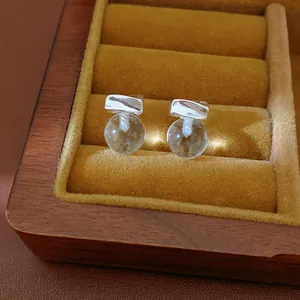Minimalist silver needle stud earrings with clear resin spheres in a luxury box