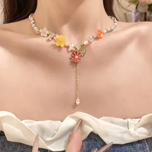 Close-up van een bohemien kralenketting met kleurrijke bloemhangers van hars op een model