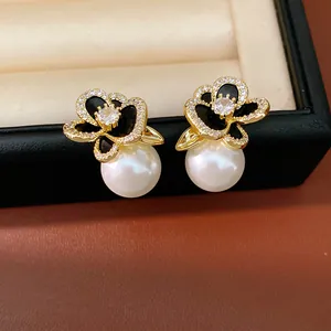 Detail of 14k gold plated floral pearl earrings with zircon inlay in a gift box