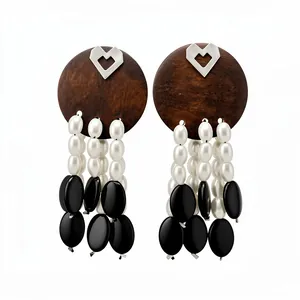 Vintage-style wood and pearl tassel earrings with silver heart detail on white background.