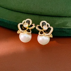 Macro detail of 14k gold plated flower earrings with cubic zirconia and white pearl