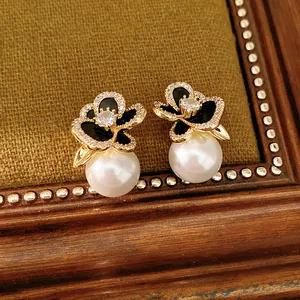 Detailed shot of 14k gold plated flower pearl earrings with sparkling zirconia