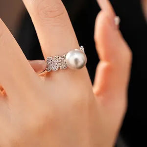 Elegant silver open ring featuring a large round pearl and pave-set zircons on hand
