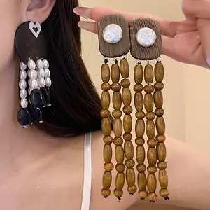 Detailed view of vintage-inspired wooden tassel earrings with elegant pearl and bead accents