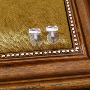 Detailed macro shot of minimalist resin ball stud earrings with premium silver needles.