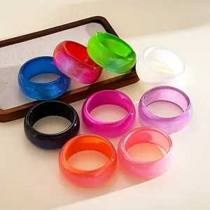 Detailed view of colorful resin phantom geometric bangles with a vibrant glittery finish