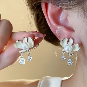 Close-up detail of elegant silver needle flower pearl stud earrings with crystal drops