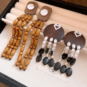 Detail shot of elegant vintage wood and pearl tassel earrings in a jewelry tray