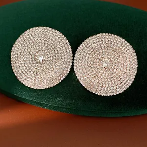 Primer plano de pendientes redondos extragrandes con pavé de strass y aguja de plata
