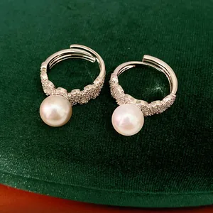 Detailed view of two adjustable silver rings featuring elegant pearls and sparkling zircons.