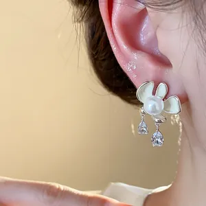Macro view of flower pearl earring with enamel petals and teardrop crystal drops