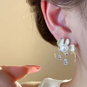 Elegant enamel flower earrings with pearl center and dangling crystal teardrops close-up