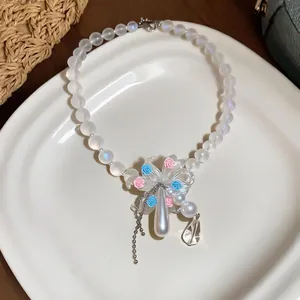 Detailed view of iridescent beaded necklace with floral pendant and pearl drop tassel