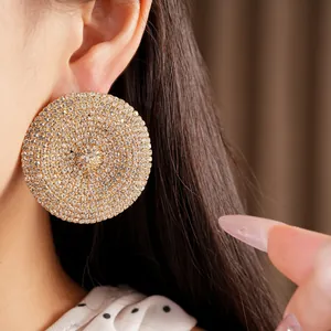 Vista detallada de pendientes de botón circulares pavimentados con strass brillante
