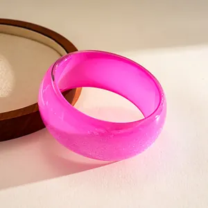 Macro detail showing the iridescent glitter inside a bright pink resin geometric bangle