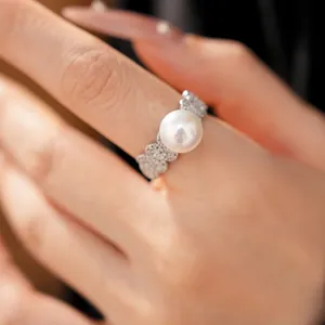 Elegant silver-toned ring with a large white pearl and pavé-set zircons shown on a finger