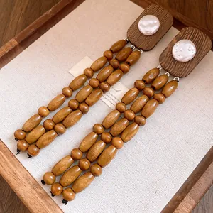 Detailed macro view of vintage wooden bead tassel earrings with white pearl inlay