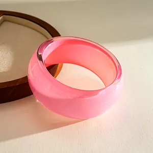 Detailed macro view of a translucent pink resin bangle with a shimmering glitter core finish
